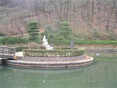 白い弁天像のある庭園の池